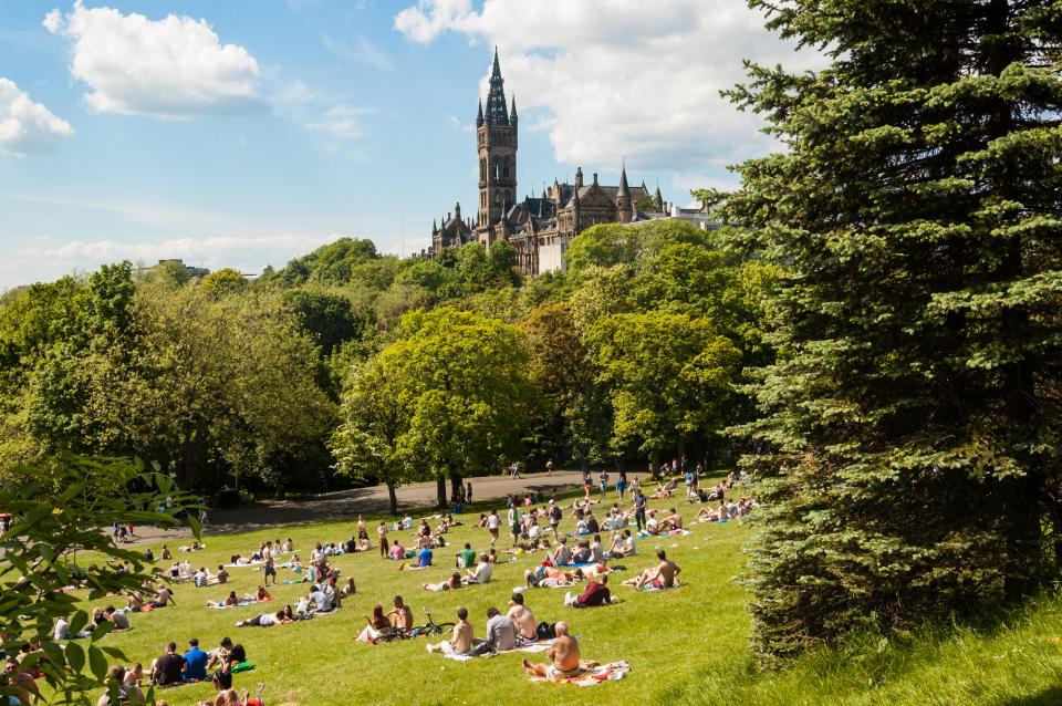 People relaxing in Kelvingrove Park with Glasgow University in the background.