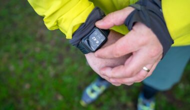 A man in yellow checks a fitness smartwatch on his wrist outside.