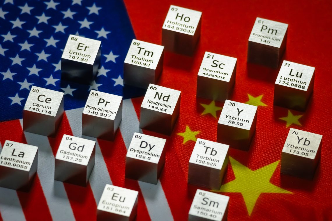 Metal cubes representing rare earth elements including Neodymium (Nd), Praseodymium (Pr), Dysprosium (Dy), Terbium (Tb) and others are displayed with their symbols and atomic numbers on overlapping flags of the United States and China.