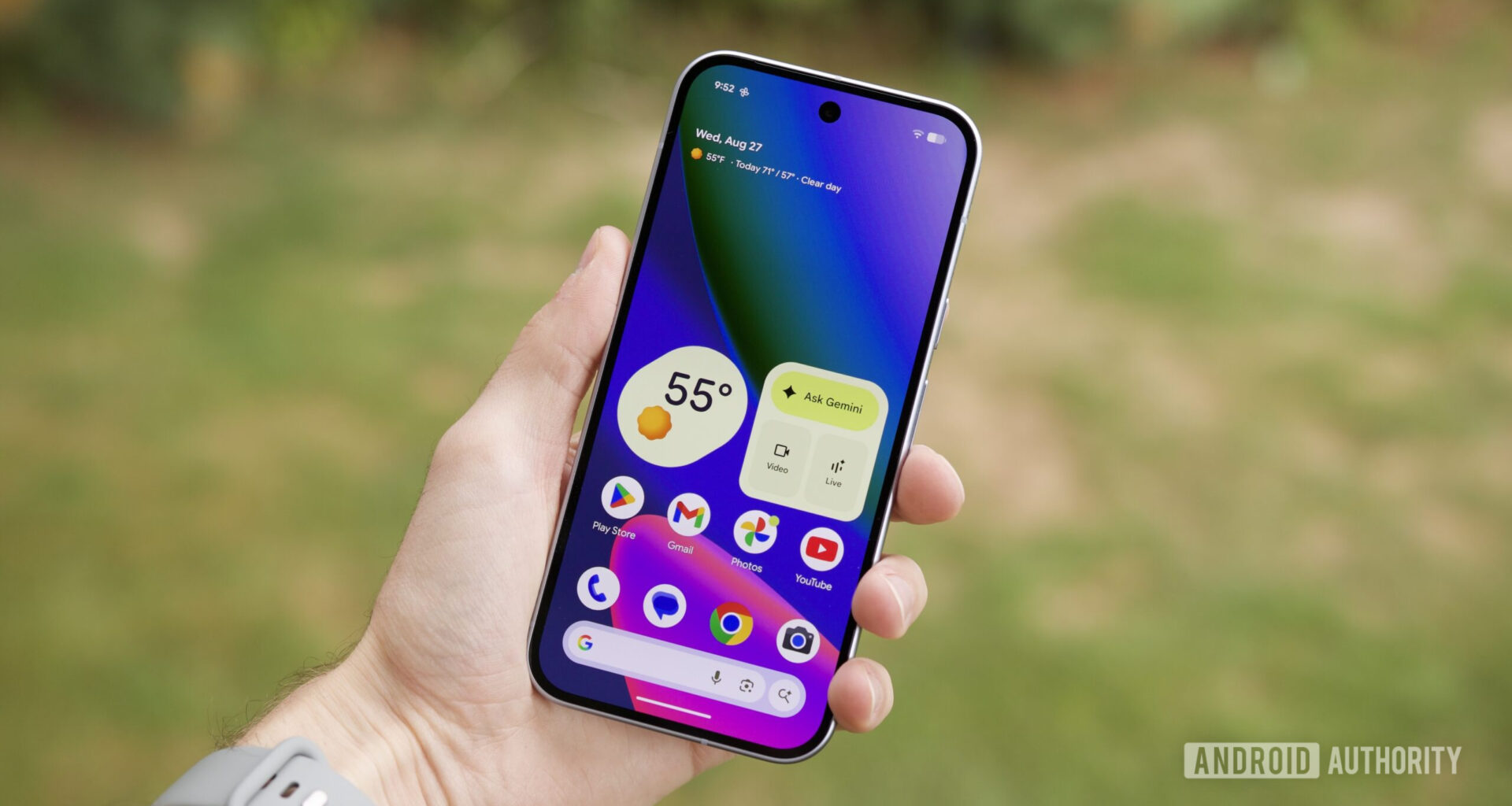 Someone holding the Google Pixel 10 with its screen on, showing the home screen.