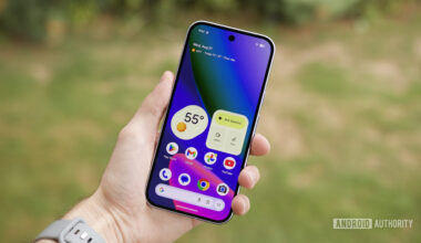 Someone holding the Google Pixel 10 with its screen on, showing the home screen.