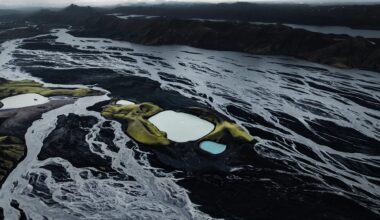a dramatic Iceland landscape photographed from the air by Dani Guindo showing rivers, a glacial lake, and a tiny plane