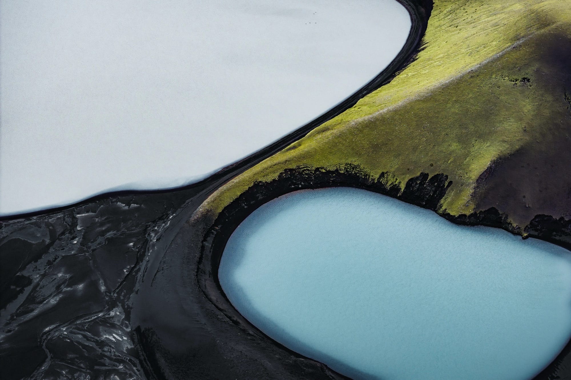a dramatic Iceland landscape photographed from the air by Dani Guindo showing rivers and bright green ground cover that looks almost abstract