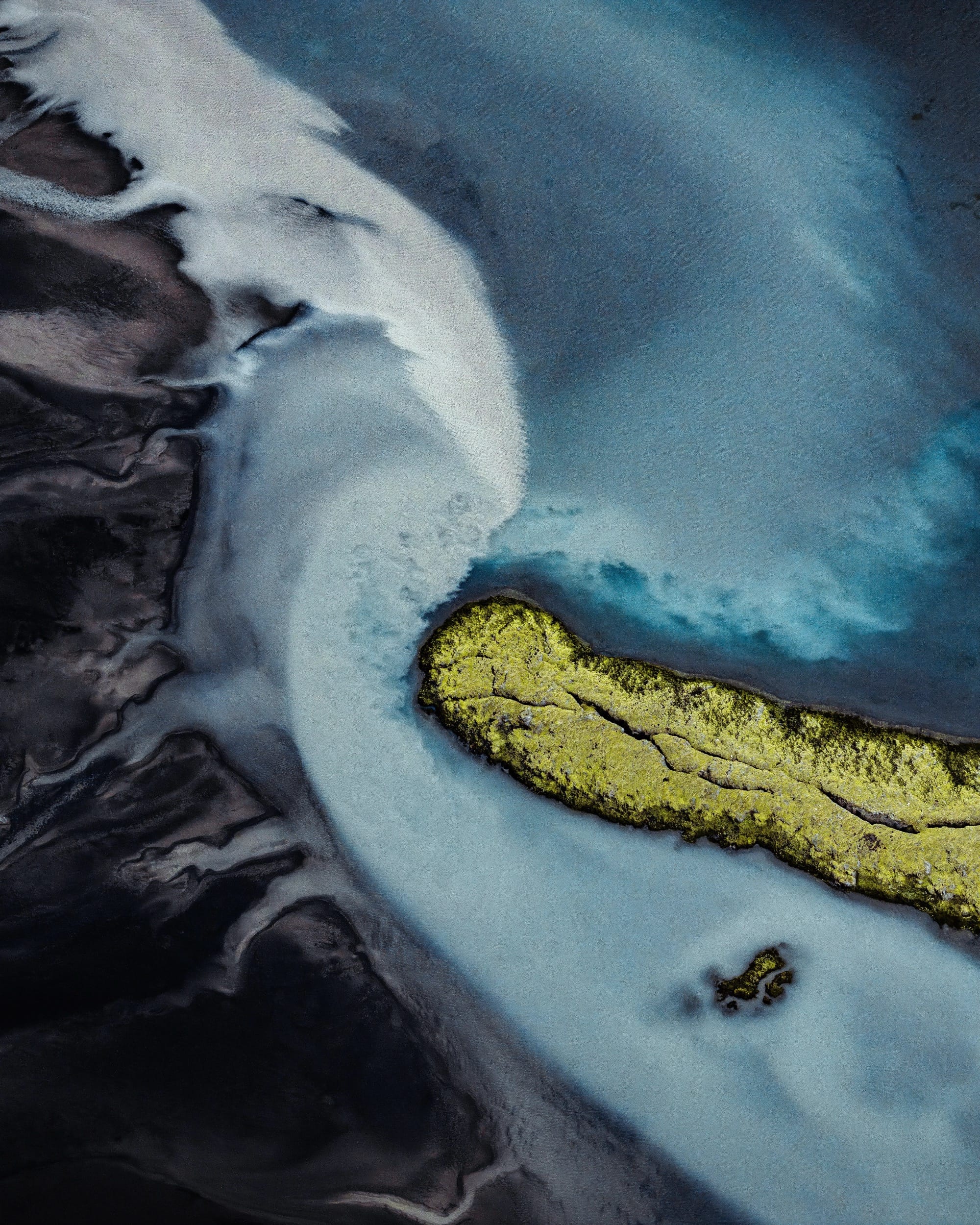a dramatic Iceland landscape photographed from the air by Dani Guindo showing rivers and bright green ground cover that looks almost abstract