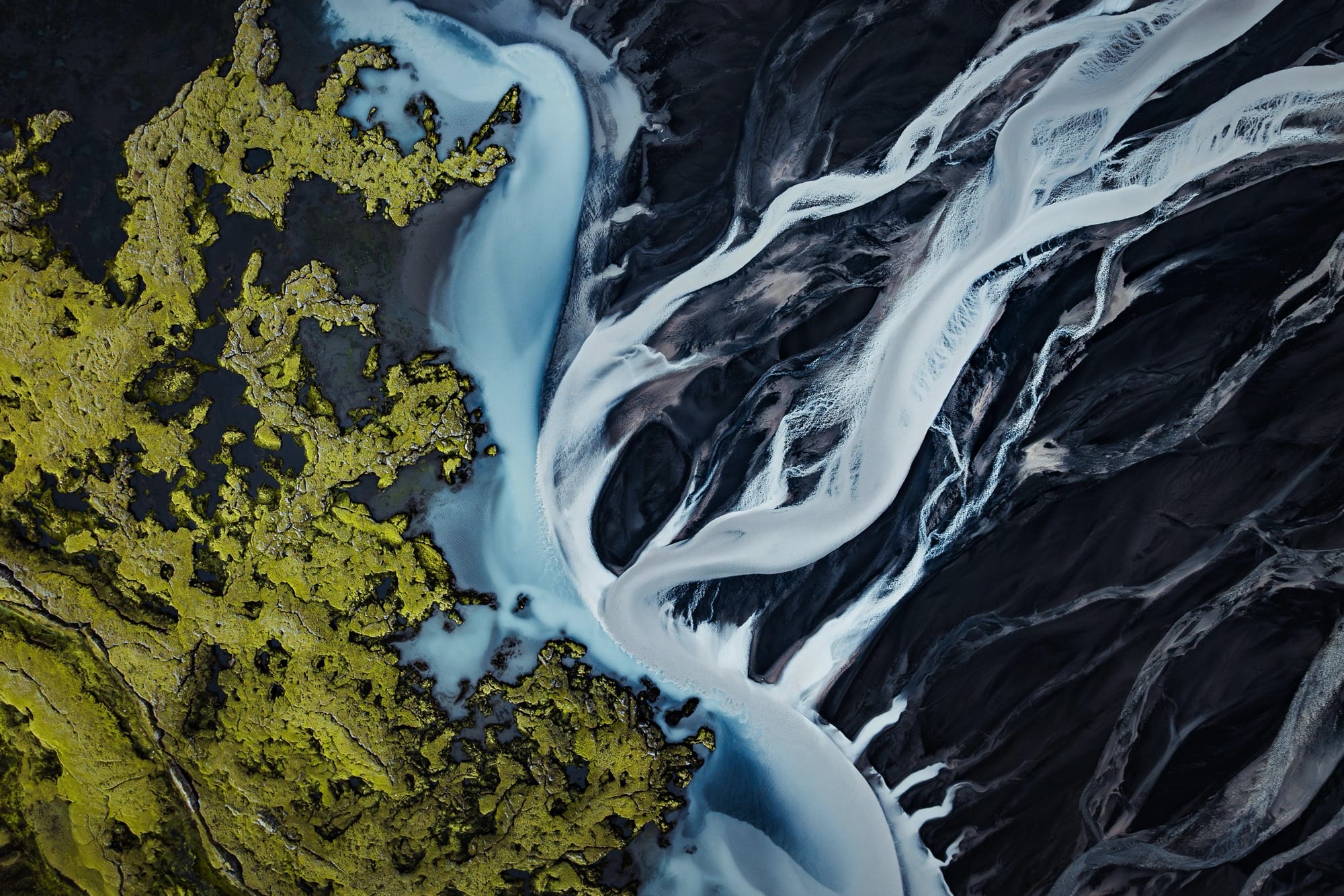 a dramatic Iceland landscape photographed from the air by Dani Guindo showing rivers and bright green ground cover that looks almost abstract