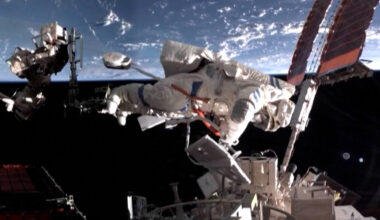 an astronaut in a white spacesuit works outside a space station with earth in the background