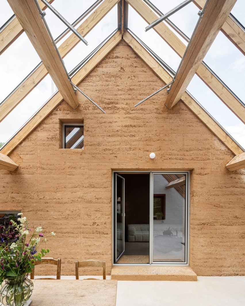 Rammed-earth wall within winter garden by Hé!