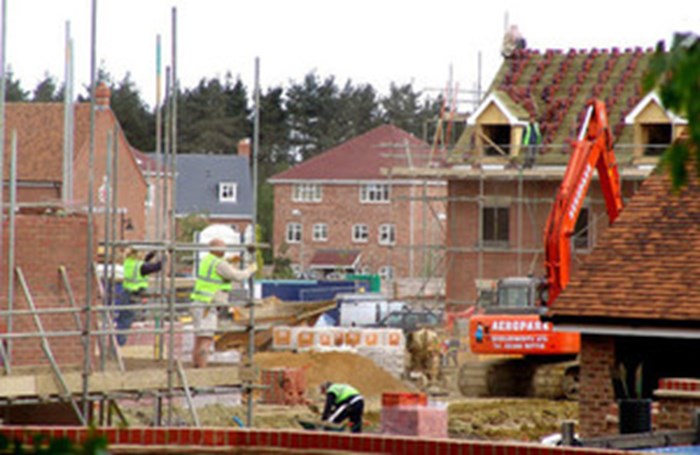 Picture of housing construction site featuring scaffolding and part built homes