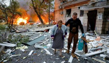 A woman receives assistance as she leaves the apartment building hit during Russian missile and drone strikes in Kyiv