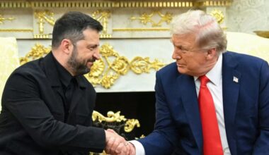 Volodymyr Zelenskyy and Donald Trump shake hands and look at each other during a meeting in the Oval Office.