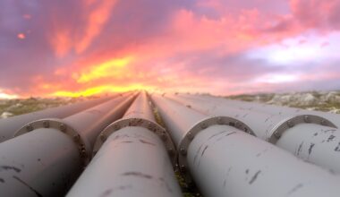 Industrial pipelines and valves on sunset sky background