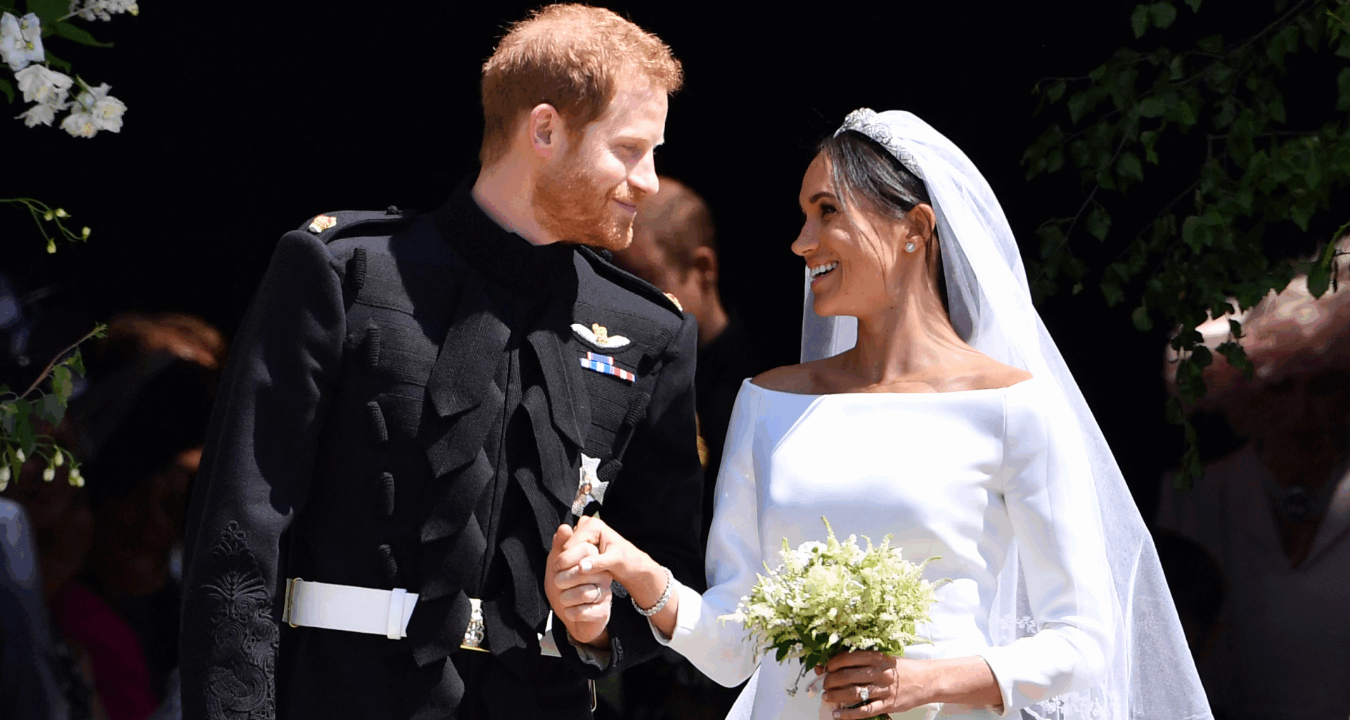 Prince Harry and Meghan Markle on their wedding day smiling at each other