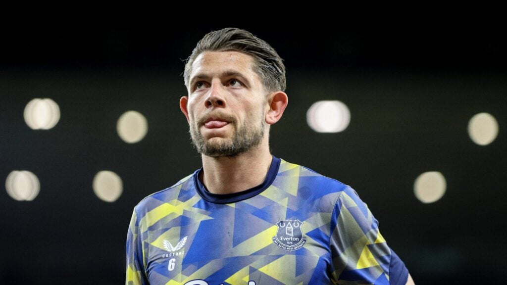 james tarkowski everton in a yellow and blue training top looking at the sky with his tongue sticking out