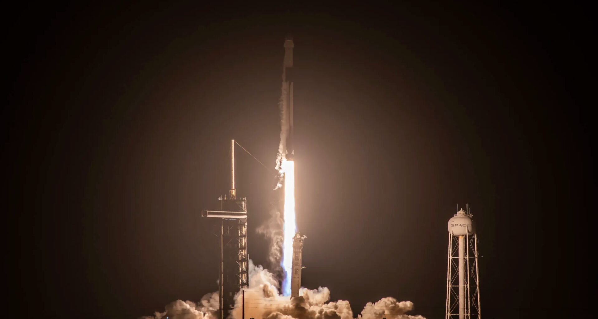 a black and white rocket launches into a dark night sky