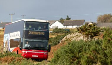 a double decker bus driving down a dirt road