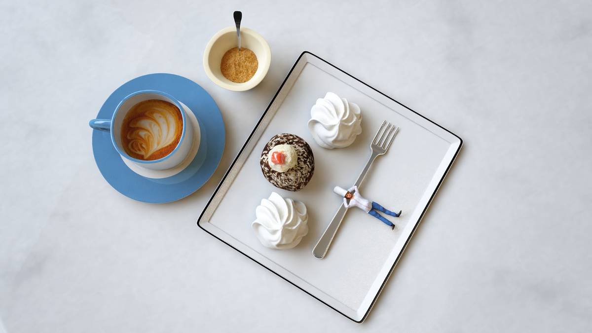 a combination of projected imagery and real food and drinks composing an image with a tiny chef lying down on a fork next to a dessert and some coffees