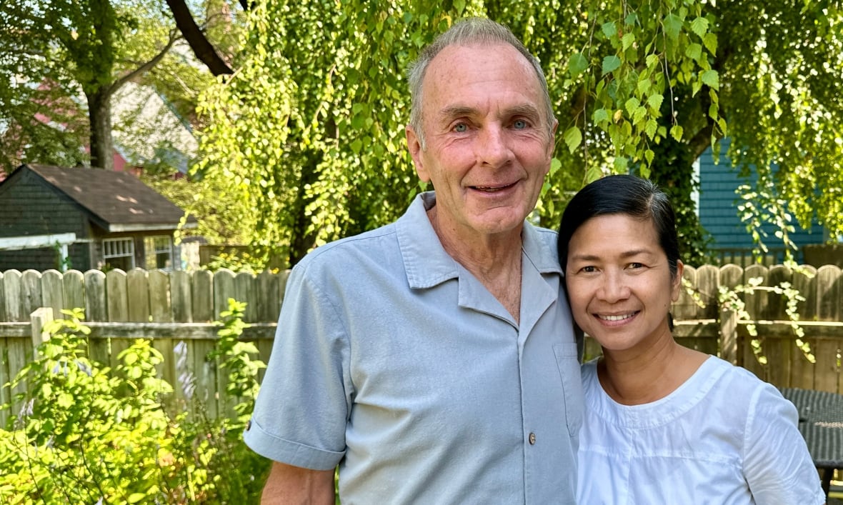 Lorne and Riza McVicar standing in their backyard. 