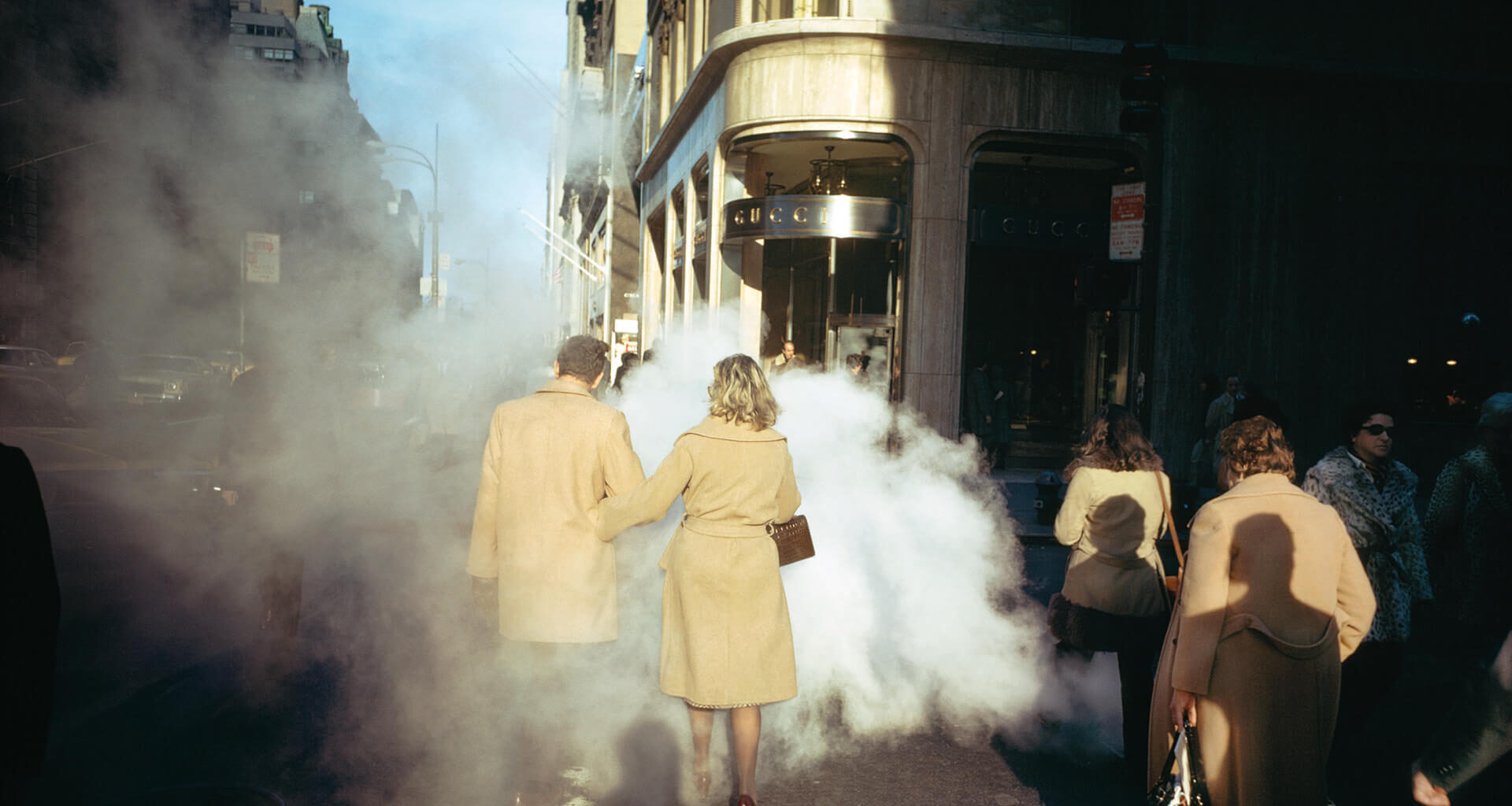A photo of people walking in Manhattan, wearing camel trench coats, by Joel Meyerowitz