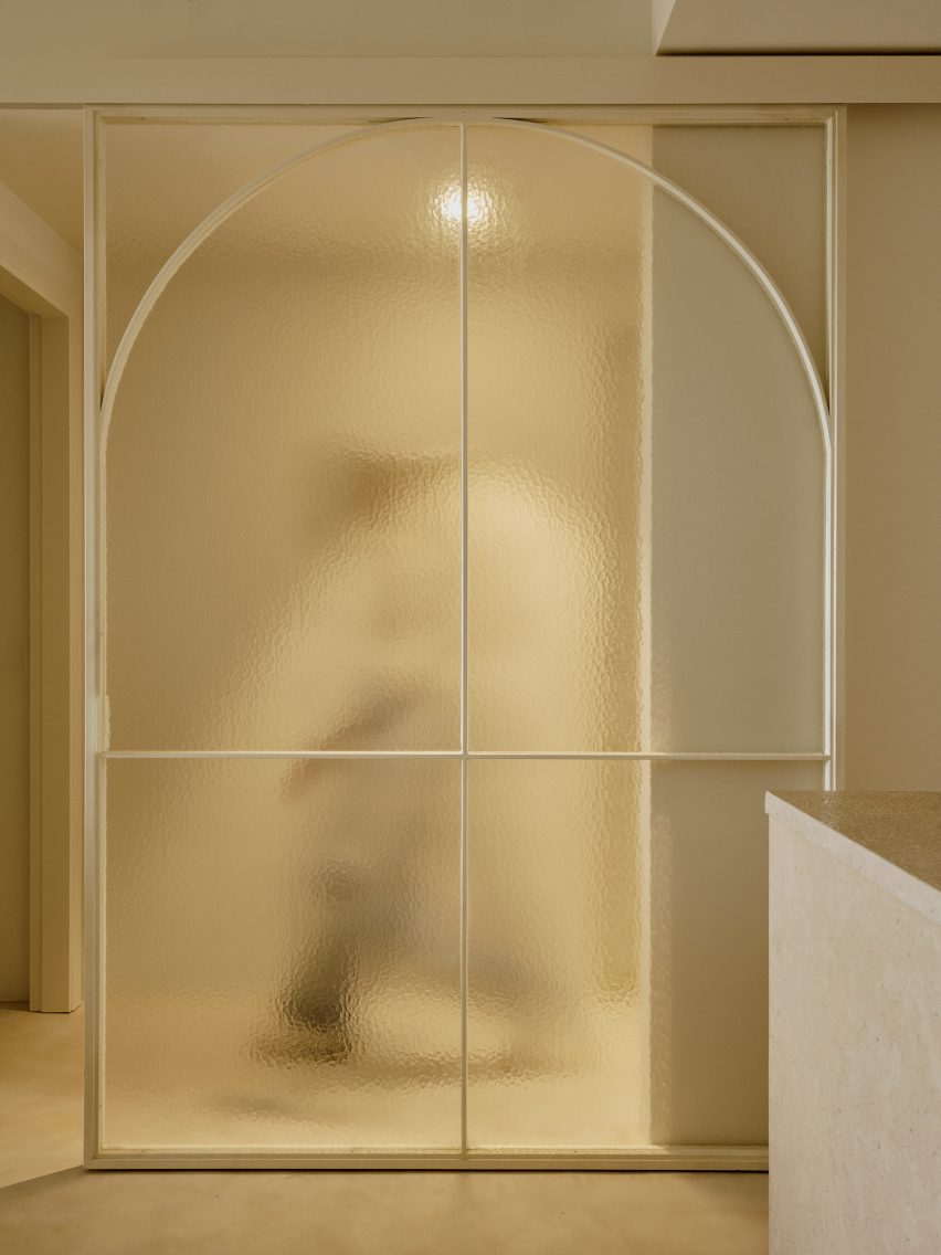 A figure walking behind a translucent glass door