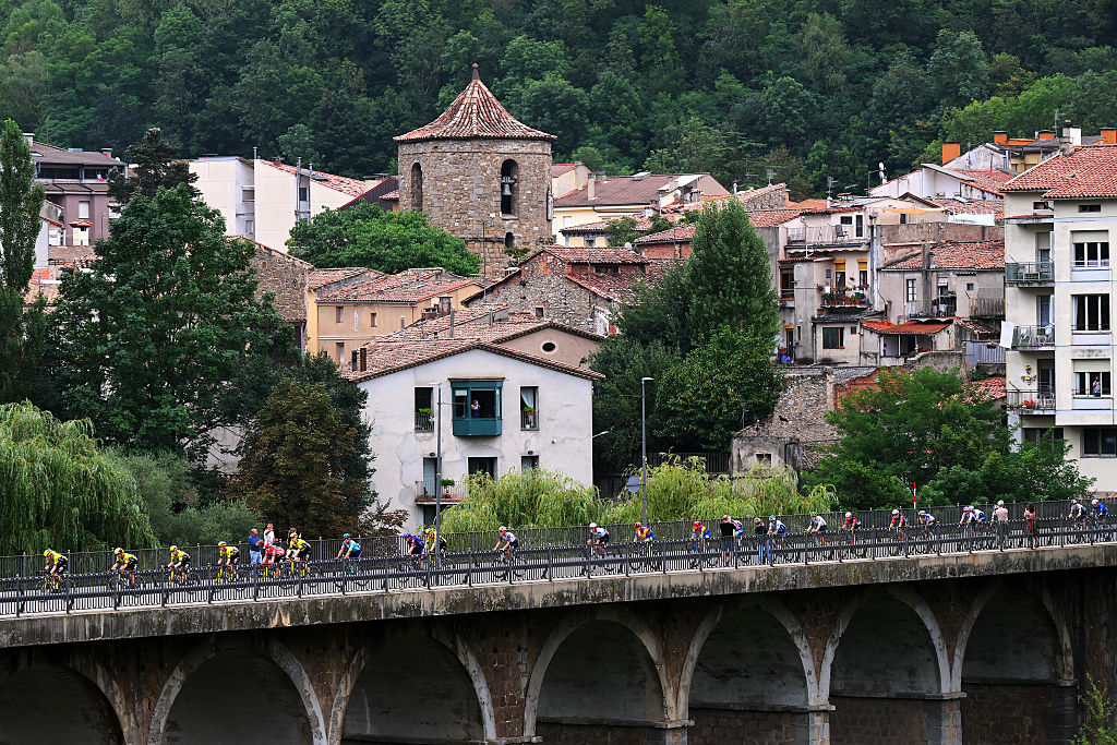 PAL, ANDORRA - AUGUST 28: Jonas Vingegaard of Denmark and Team Visma | Lease a Bike - Red Leader Jersey and a general view of the peloton passing Sant Joan de les Abadesses Village during the La Vuelta - 80th Tour of Spain 2025, Stage 6 a 170.3km stage from Olot to Pal - Andorra 1900m / #UCIWT / on August 28, 2025 in Pal, Andorra. (Photo by Tim de Waele/Getty Images)