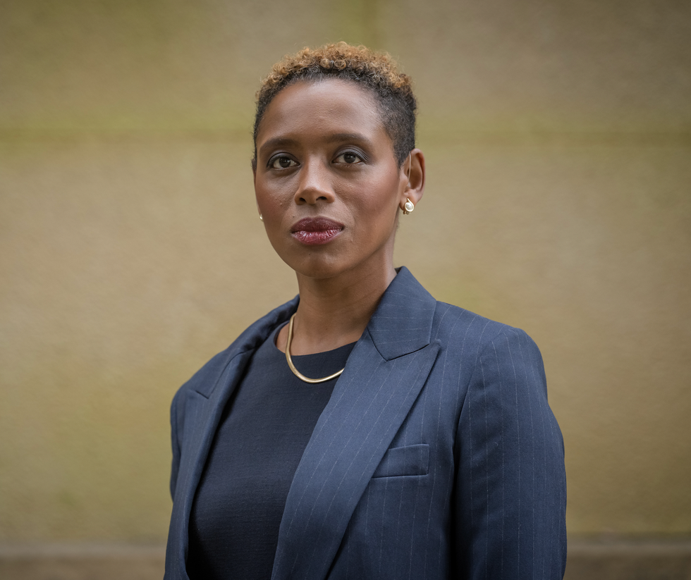 professional portrait of a person wearing a business suit and gold jewelry