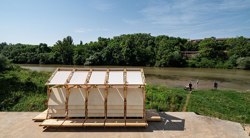 shaded wooden pavilion by erazo pugliese reclaims neglected dock along river in spain
