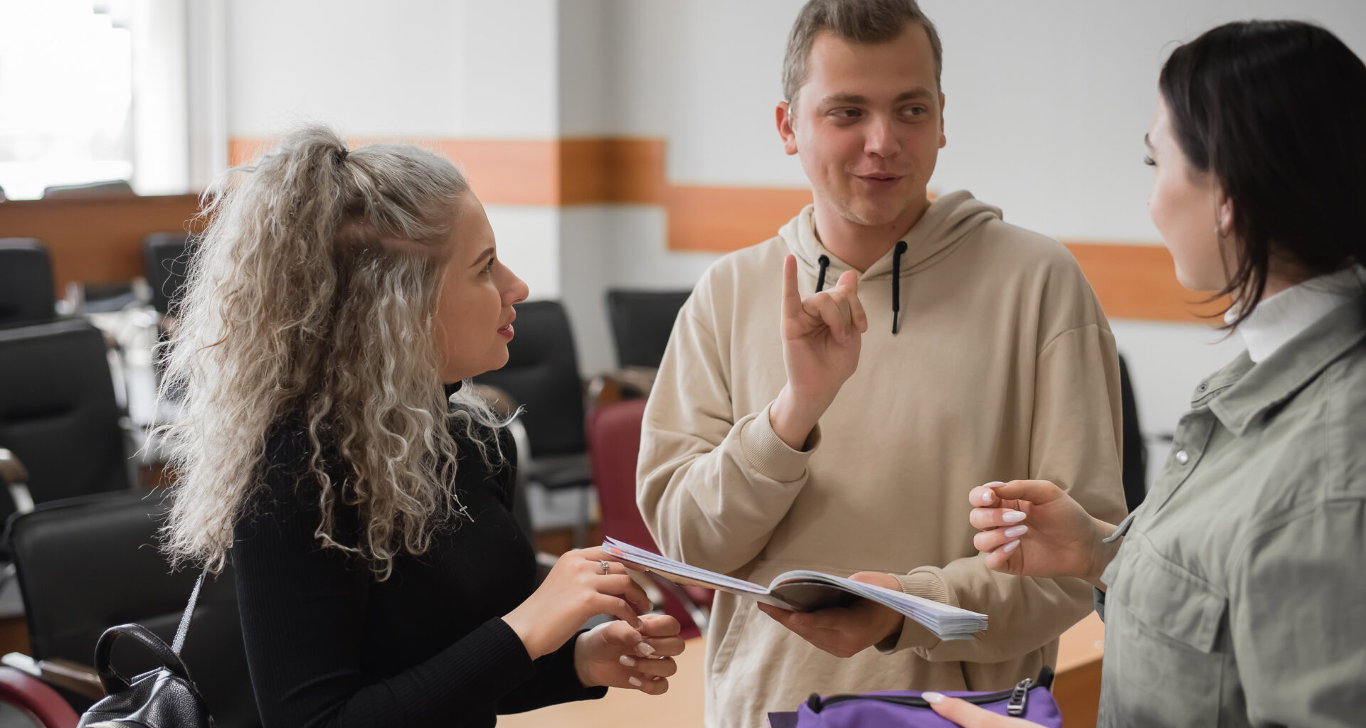 Image of three young people signing to each other