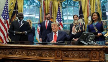 Donald Trump holds a picture of himself with Rwanda's foreign minister Olivier Nduhungirehe, at a meeting in June. Pic: Reuters