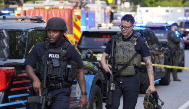Armed police officers walk near the scene of the shooting. Pic: AP