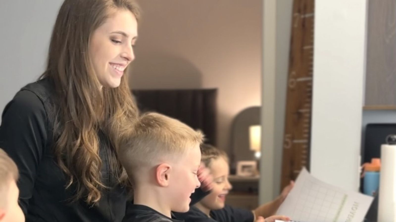 Jonah, middle, flicks through a financial planner with mum Samantha