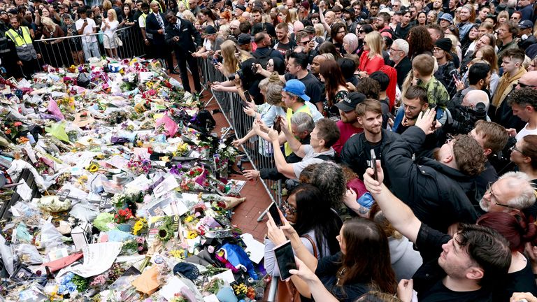 People gather around flowers placed at the Black Sabbath Bridge. Pic Reuters