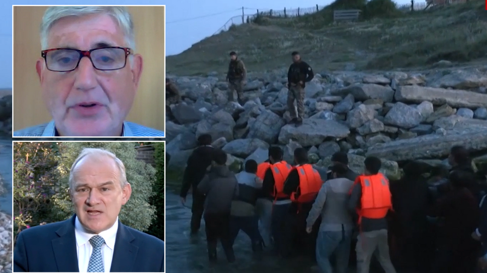 Tony Smith, Ed Davey and migrants pushing a small boat into the water