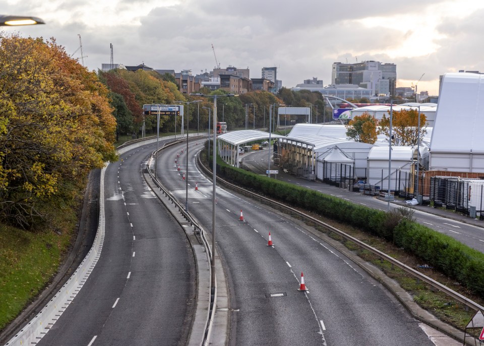 Empty Glasgow road with traffic cones and closed-off lanes.
