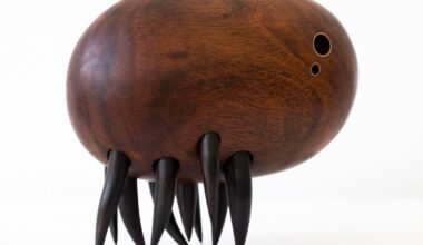 a wooden sculpture by Donald Wasswa with an abstract, sea creature-like form with short, black tentacles