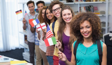 Young students waving flags of different countries.