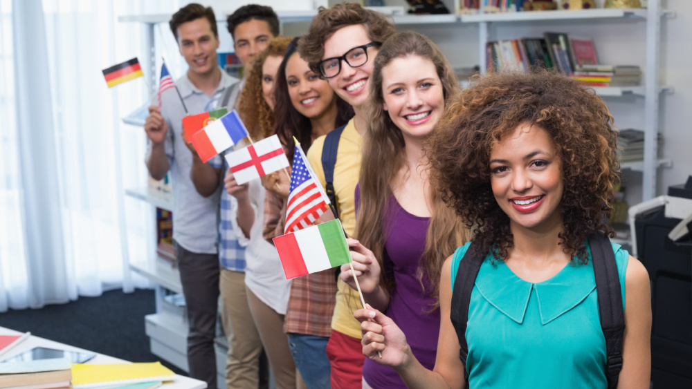 Young students waving flags of different countries.