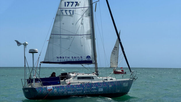 Jazz Turner aboard her mermaid-scale decorated 27ft 1975 Albin Vega yacht FEAR. Credit: David Martin