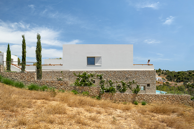 pieris.architects embeds layered stone-and-plaster residence into greek hillside