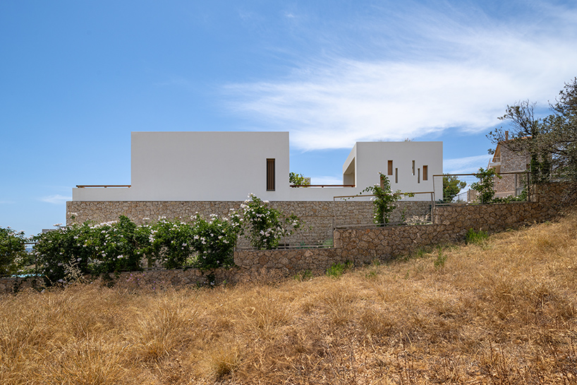 pieris.architects embeds layered stone-and-plaster residence into greek hillside