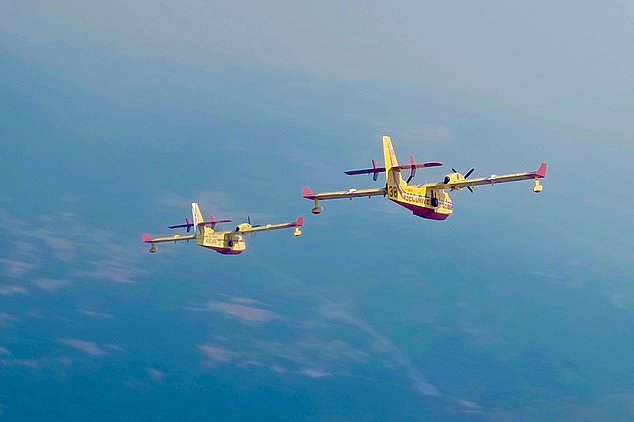 This recent photo provided by the Securite Civile shows two French Canadair water bombers flying over Spain. (Securite Civile via AP)