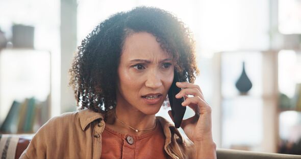 woman speaking on smartphone while sitting at sofa