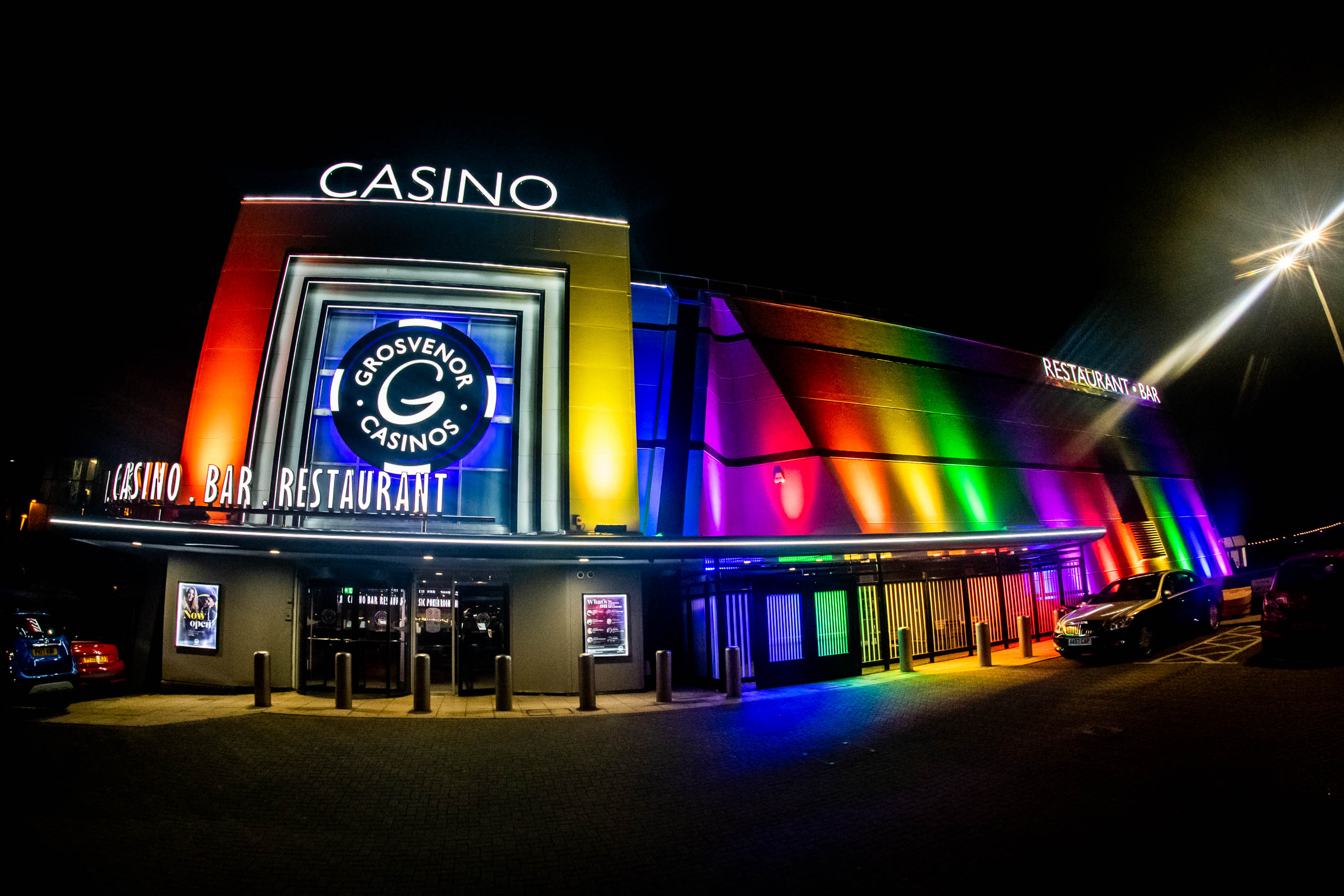 Grosvenor Casino in Blackpool at night, illuminated in rainbow colors.