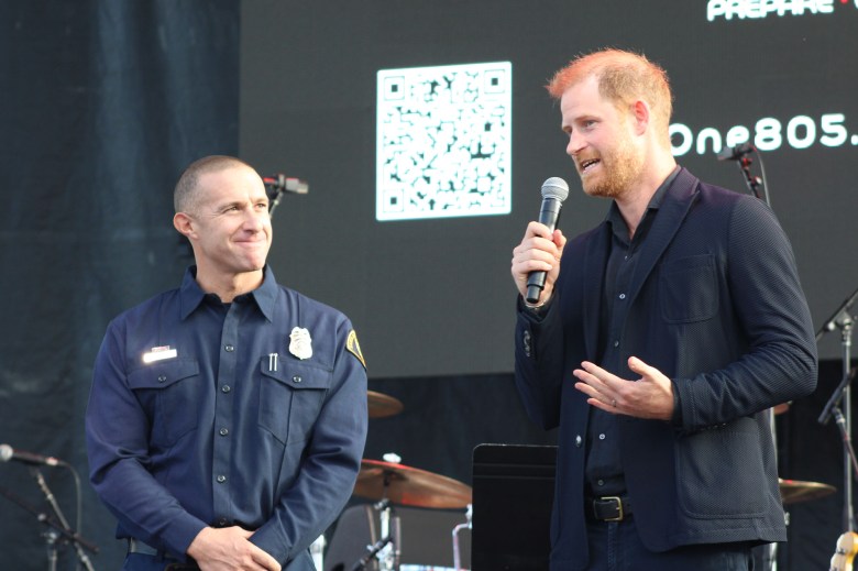 Prince Harry joins firefighter Sam Dudley and his rescue dog, Rhonda, onstage. The prince presented Chief Mark Hartwig with the organization Heart of the Community for the Santa Barbara County Fire Department's Peer-to-Peer mental health program.