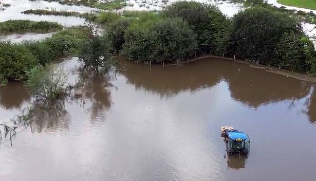 A large flooded field with a tractor visible among the water