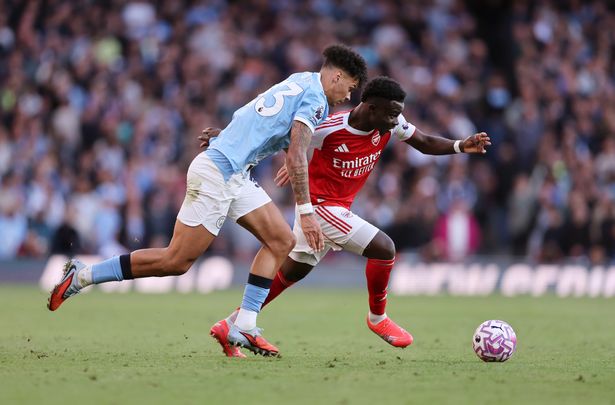 Nico O'Reilly of Manchester City gets to grips with Bukayo Saka