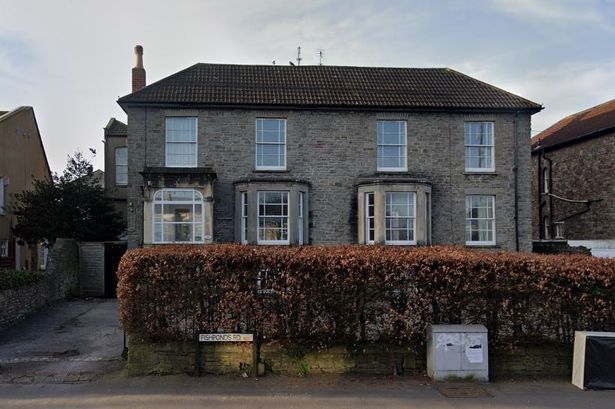 GV of large house behind hedgerow