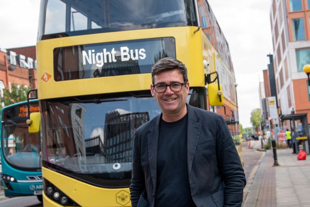 Andy Burnham poses in front of a night bus