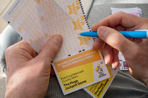 Close up of man filling in EuroMillions Lotto lottery form.
