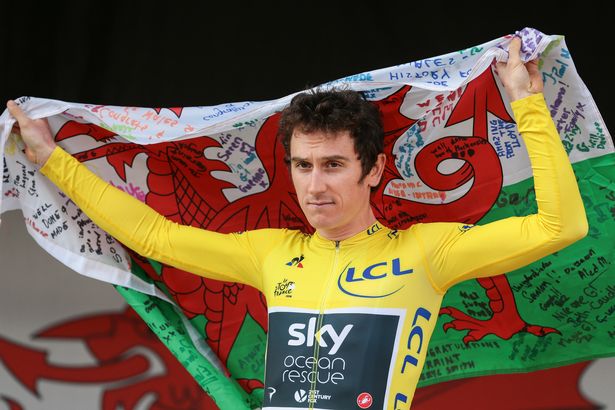 Geraint Thomas holds a signed Welsh flag during the homecoming event in Cardiff in 2018