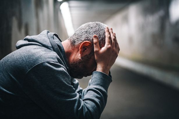 A man holding his head in his hands